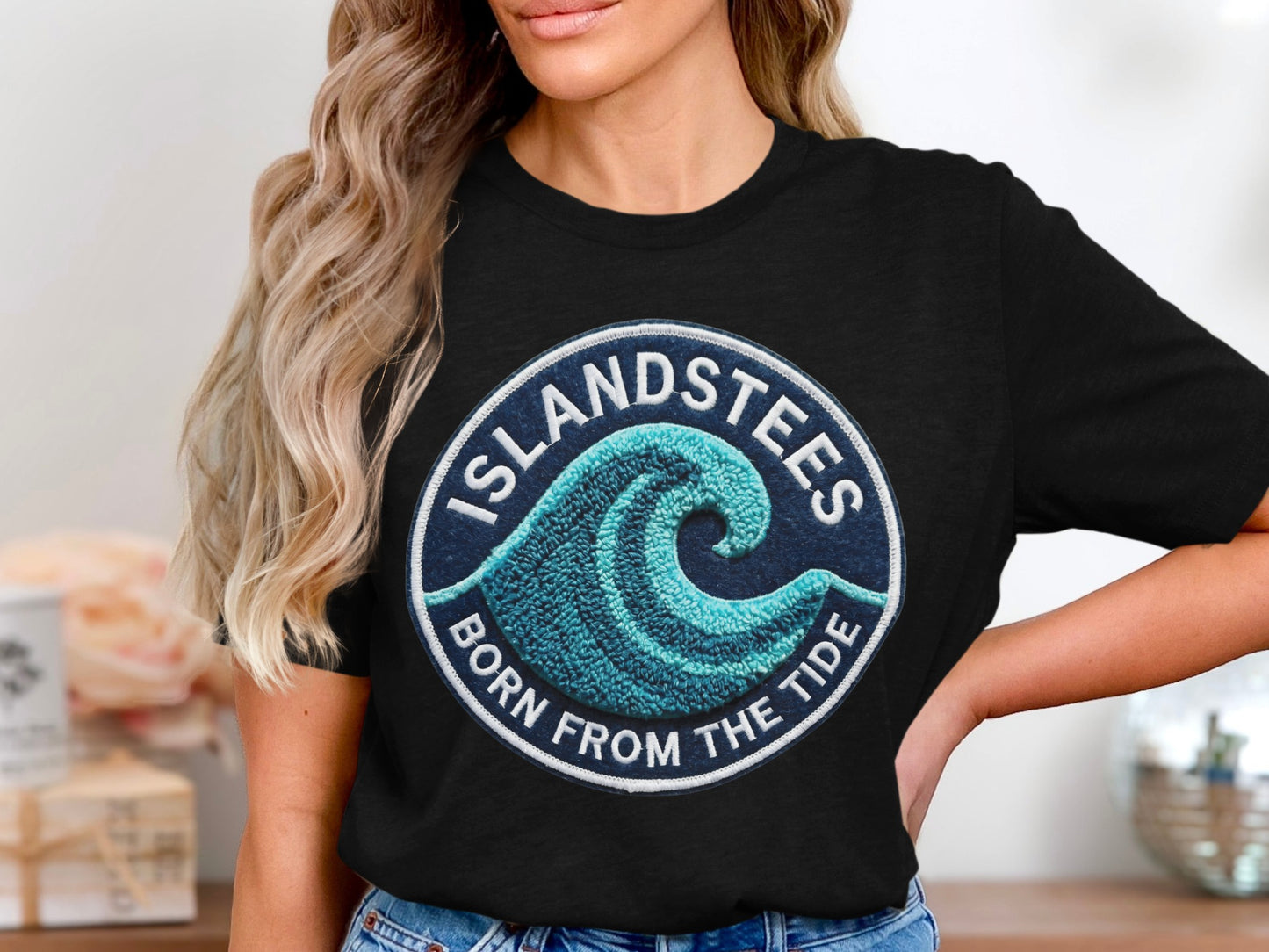 Black t-shirt with circular "ISLANDSTEES BORN FROM THE TIDE" wave logo.