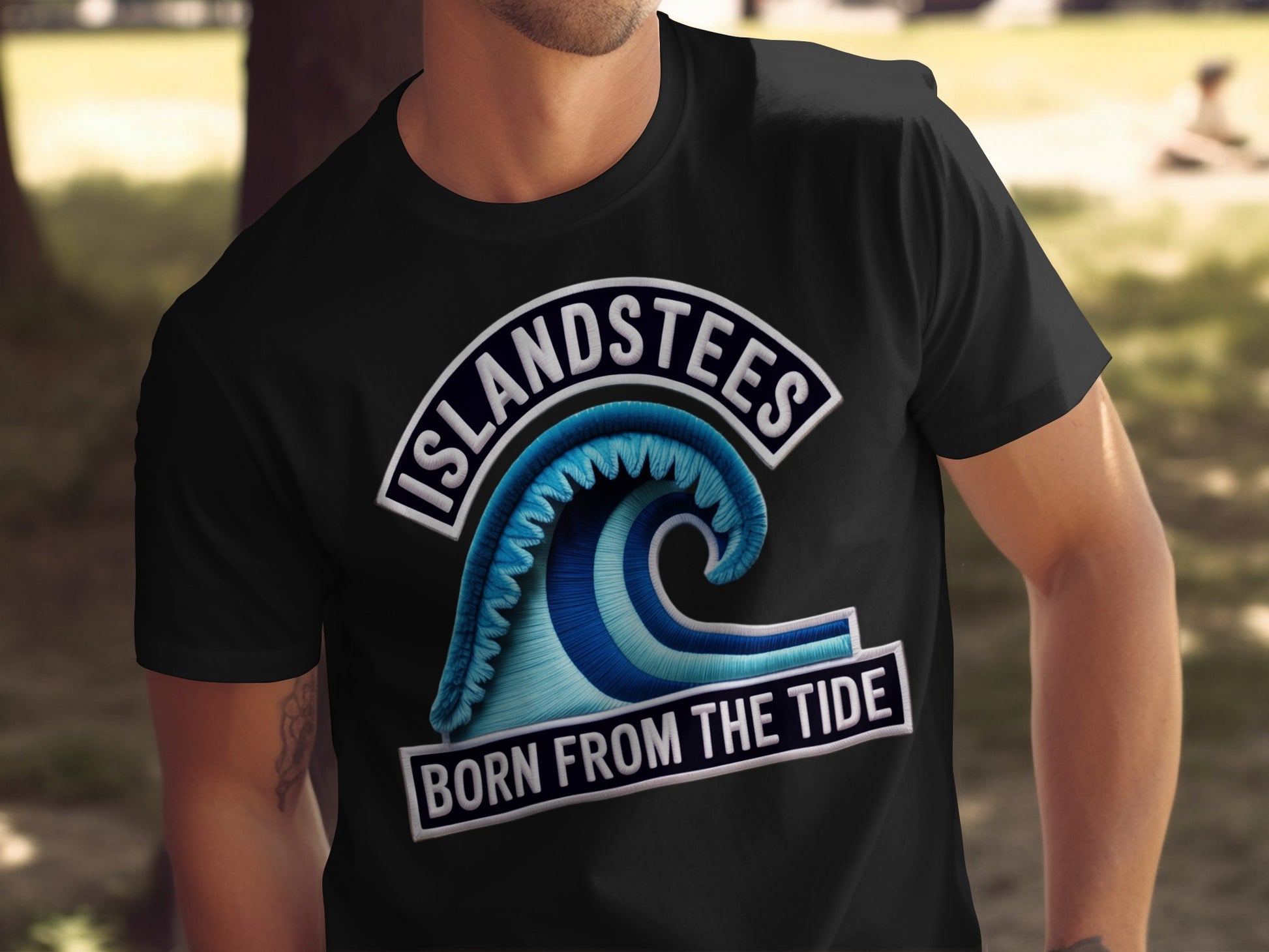 Black t-shirt with "ISLANDSTEES BORN FROM THE TIDE" and a blue wave graphic.