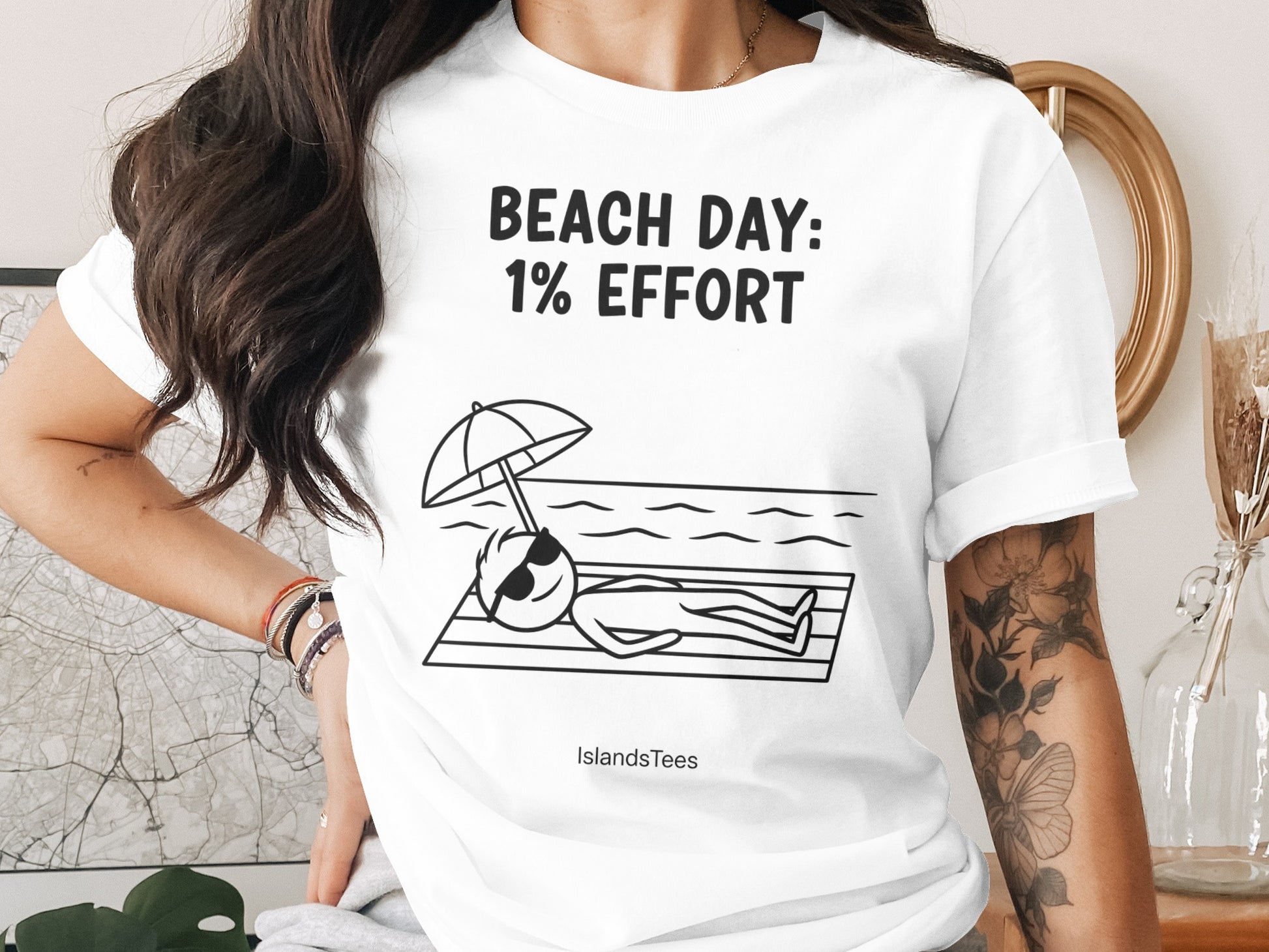 Black graphic of a stick figure relaxing on a beach towel under an umbrella, text "BEACH DAY: 1% EFFORT".
