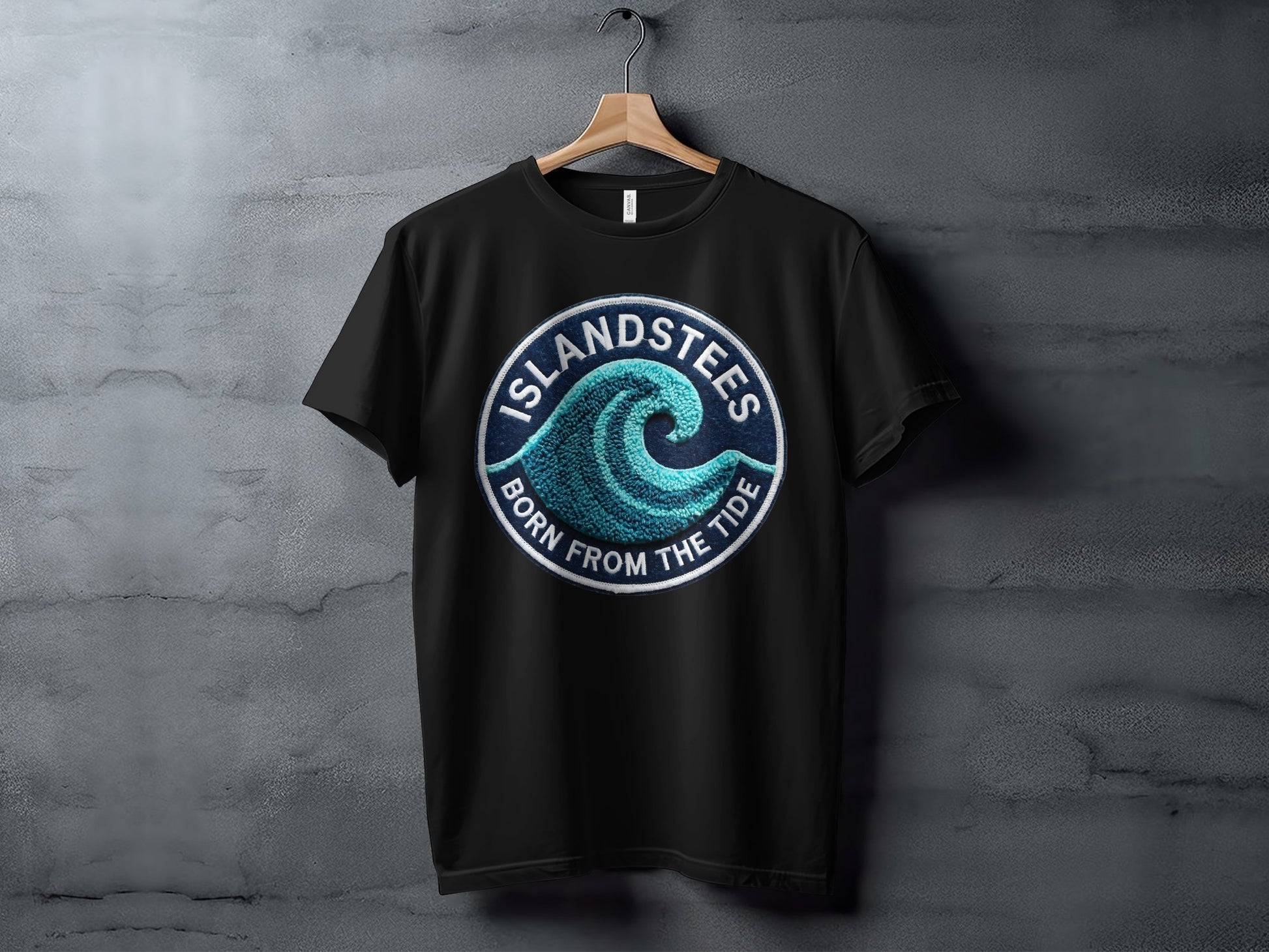 Black t-shirt with round "Islandstees Born From The Tide" wave logo.