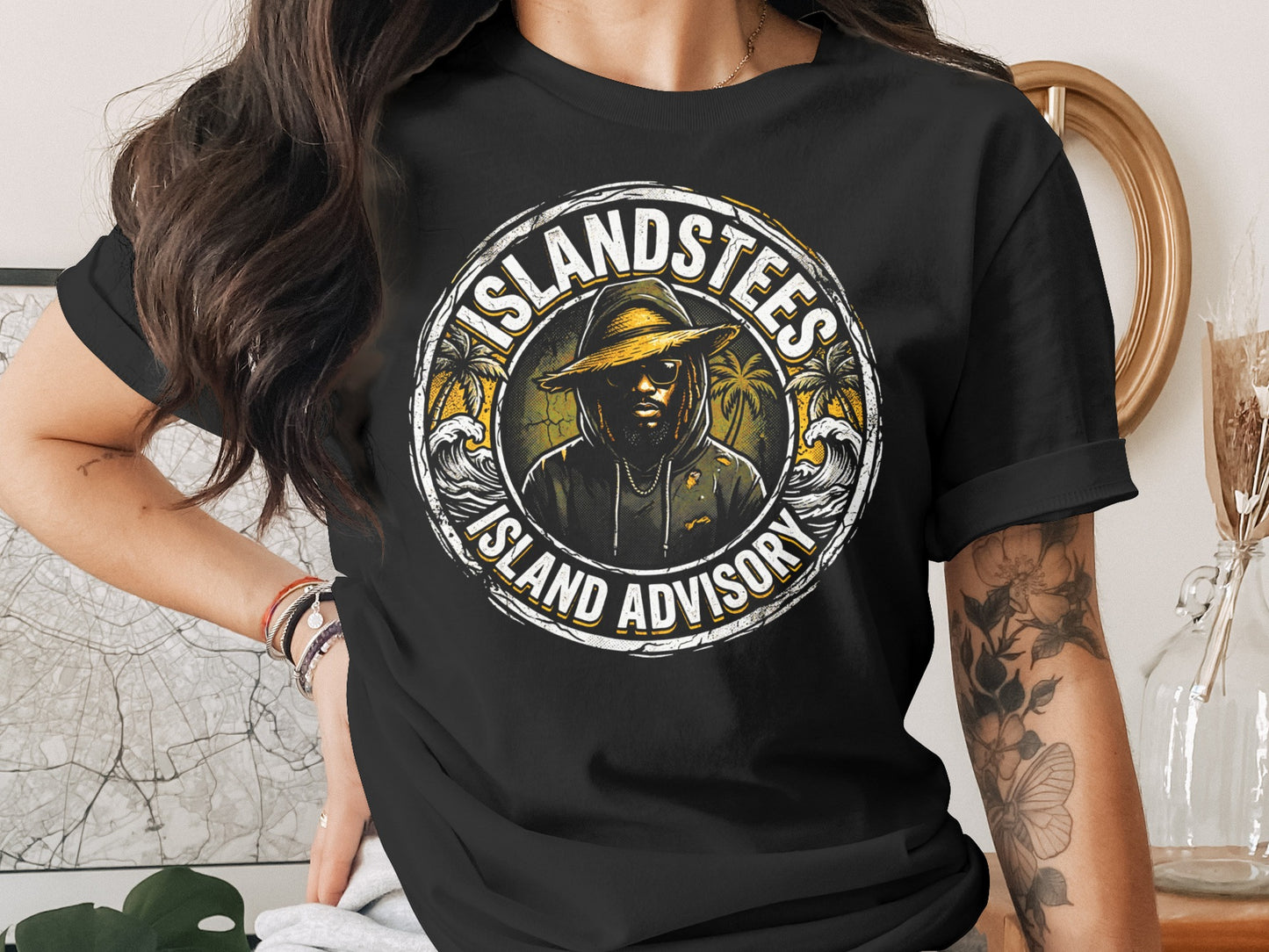Black t-shirt featuring a circular graphic with "ISLAND TEES ISLAND ADVISORY" and a silhouetted person.