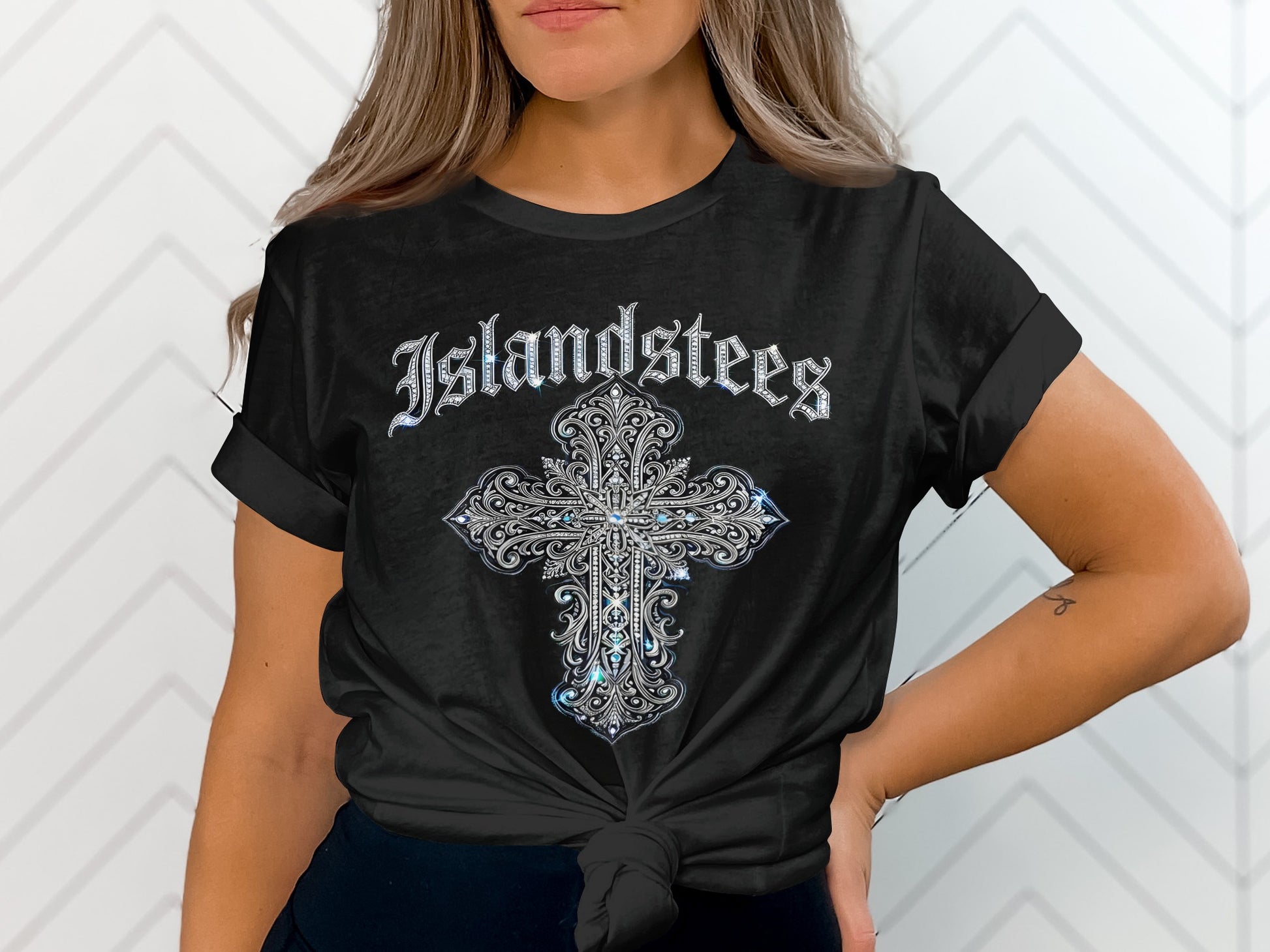 Black t-shirt with ornate silver cross and "Islandstees" text.