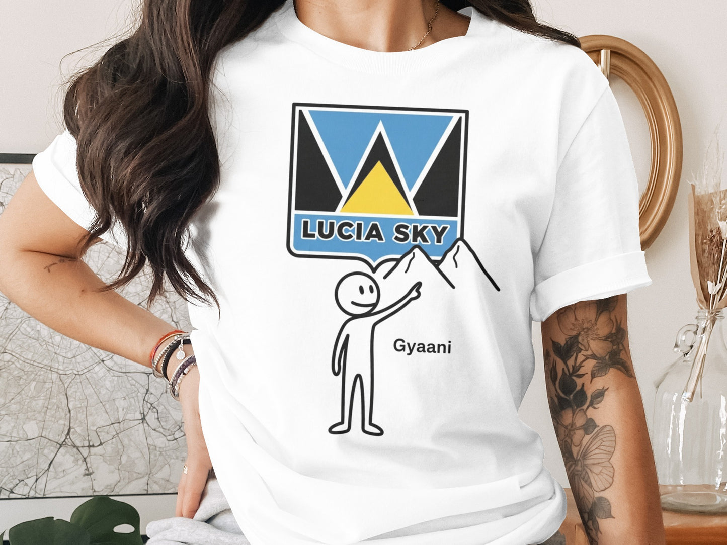 White t-shirt with "Lucia Sky" logo featuring a stylized mountain and the word "Gyaani".