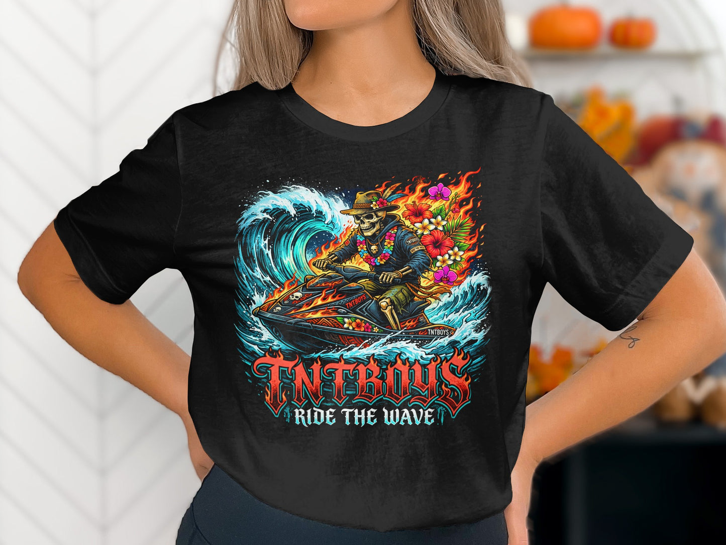 Skeleton riding a jet ski through a fiery wave, with "TNTRAX RIDE THE WAVE" text.