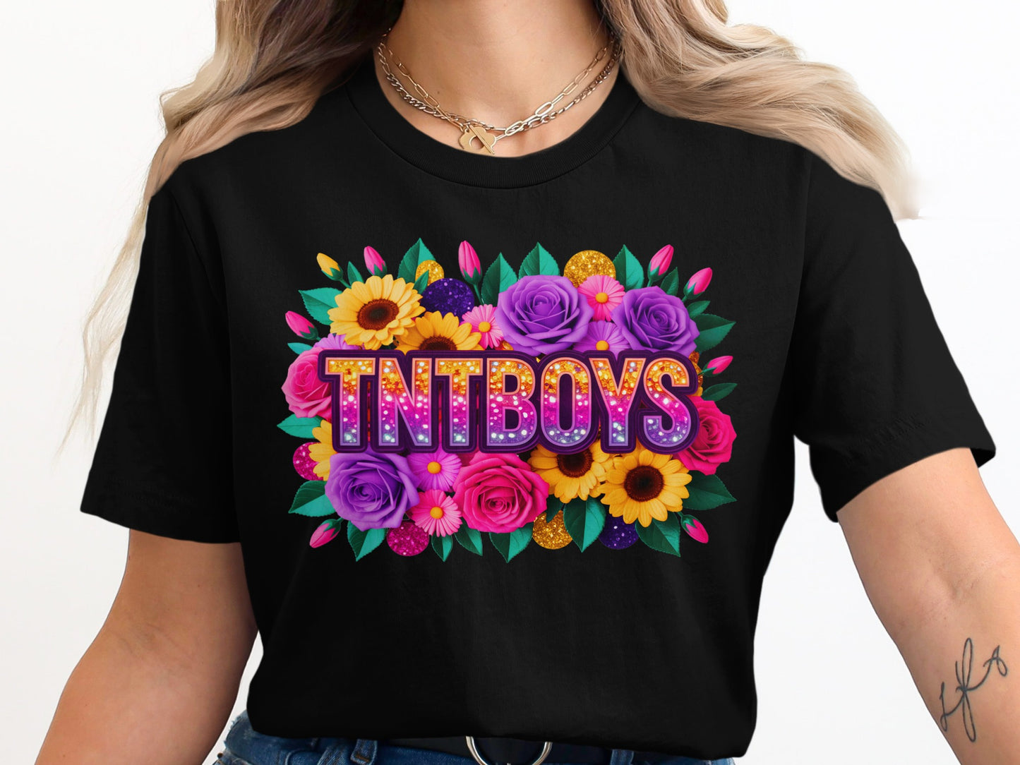Black t-shirt featuring "TNTBOYS" in colorful glitter lettering surrounded by flowers.